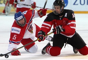ZUG, SWITZERLAND - APRIL 19: Canada's Matt Barzal #14 plays the puck from his knees as the Czech Republic's Michael Spacek #15 looks on during preliminary round action at the 2015 IIHF Ice Hockey U18 World Championship. (Photo by Francois Laplante/HHOF-IIHF Images)